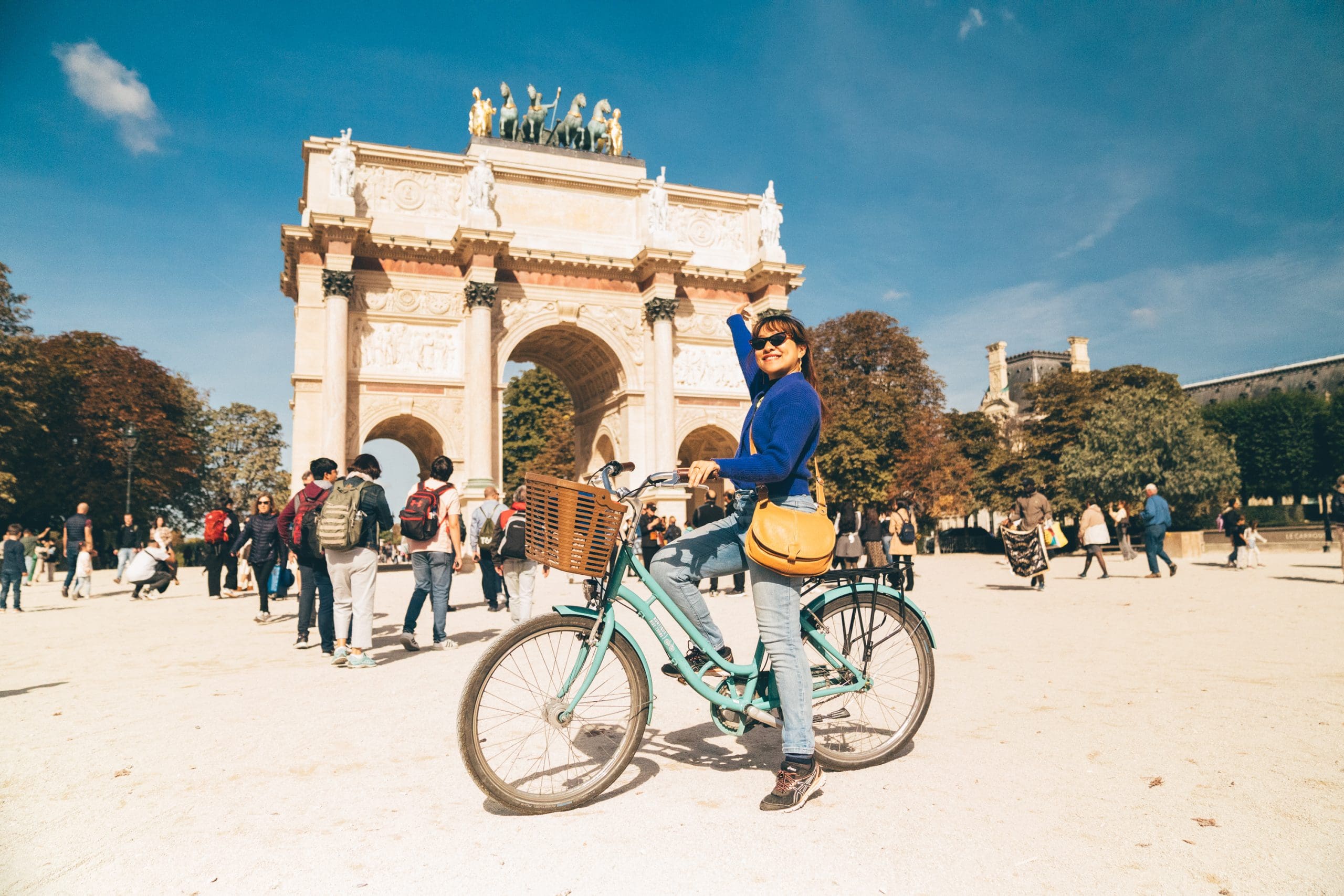 Guest with Bike Smiling at Arc de Triomphe du Carrousel - Paris Highlights Bike Tour